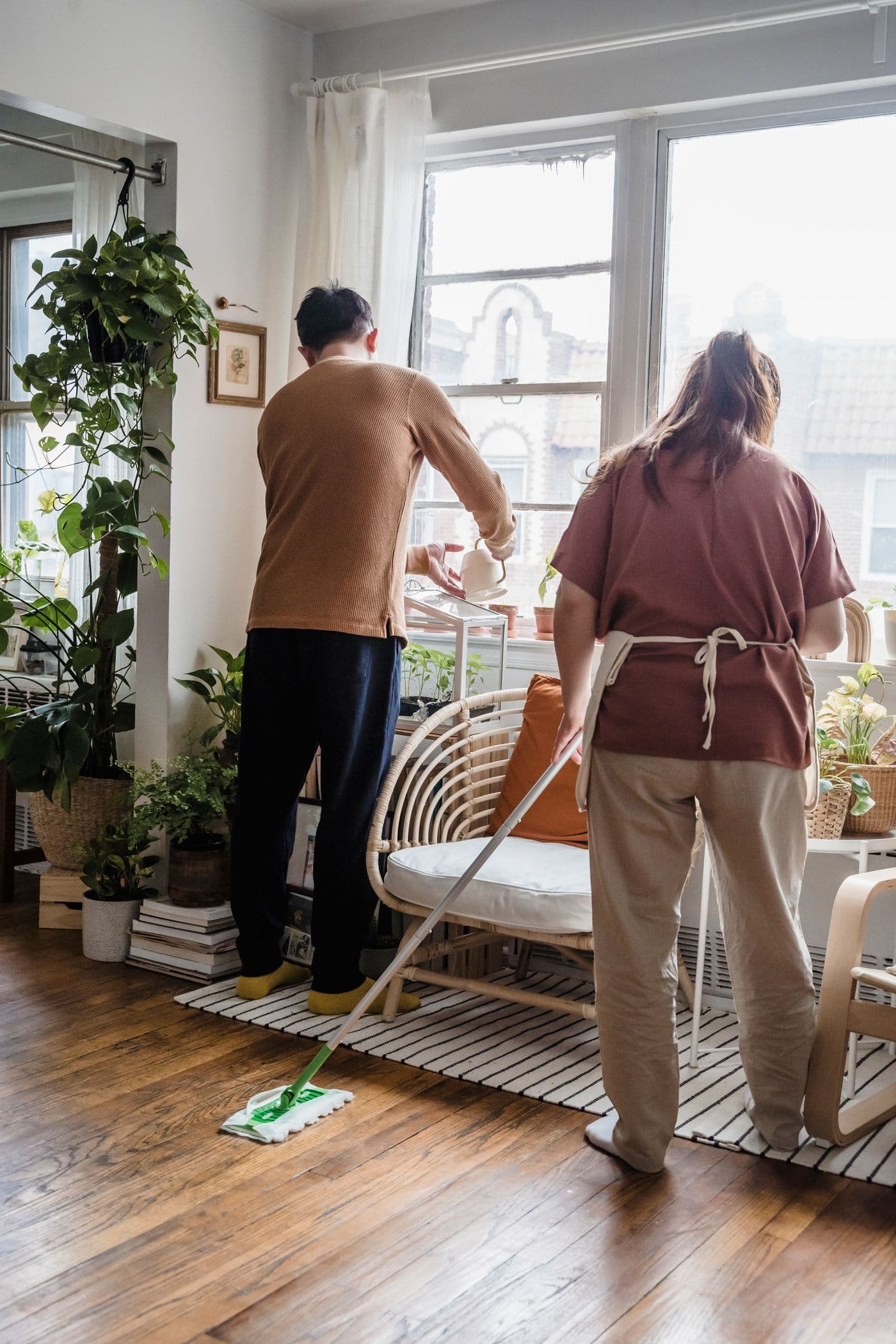 Independent cleaners working together in a bright living room