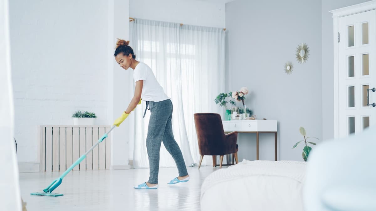 Independent cleaner mopping a bright living room